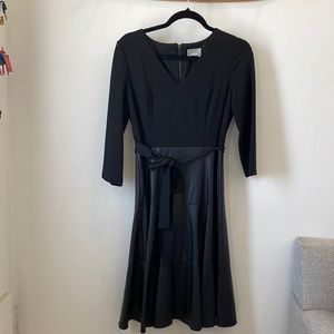 Black 3/4 sleeve cocktail dress. Jersey fabric on top . Faux leather shirt .